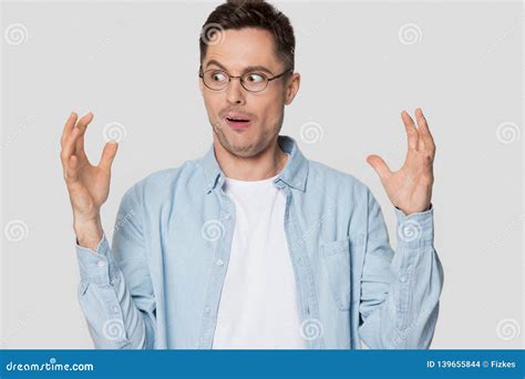 Funny Shocked Young Man Looking At Hands Showing Something Huge Stock