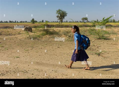 Young Indian Girl In School Uniform Walking Barefoot To Her School
