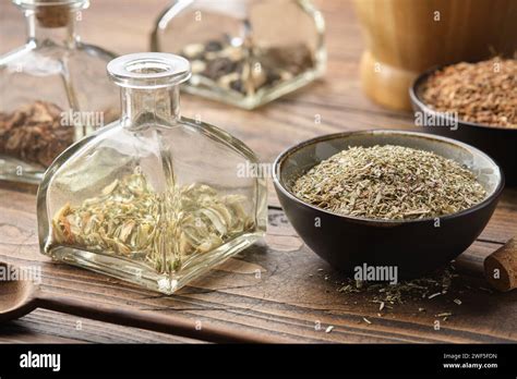 Bottle Of Dry Herbs For Making Healing Infusion Or Tincture Bowls Of