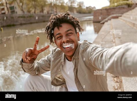 Guy Smiling At Camera Showing Freedom Sign Stock Photo Alamy