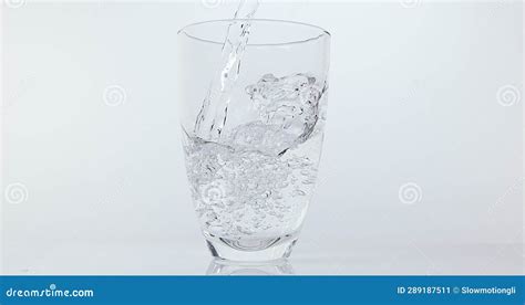 Water Being Poured Into Glass Against White Background Stock Image