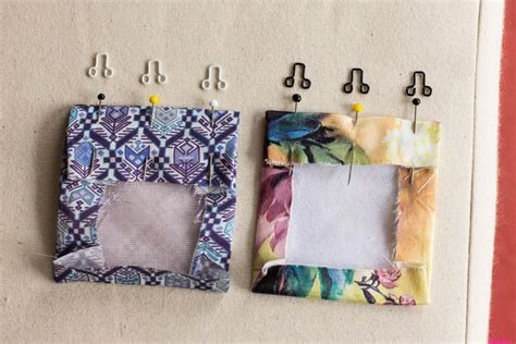 Two Pieces Of Fabric Are Next To Each Other With Clothes Pins On The Pegs