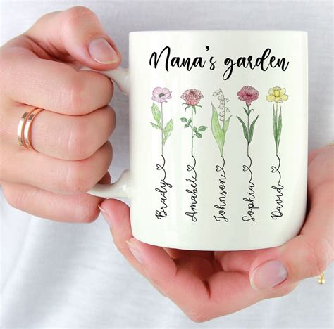 A Woman Is Holding A Coffee Mug With Flowers On It And The Words Nanas