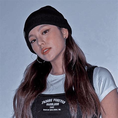 A Woman With Long Brown Hair Wearing A Black Hat And White T Shirt Is