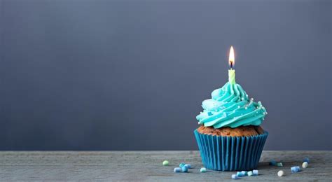 Um Cupcake Cobertura Azul E Uma Vela Acesa Foto Premium