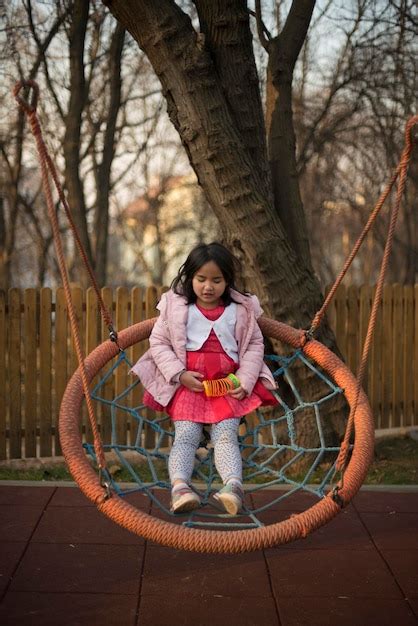 Premium Photo Full Length Of Girl Sitting On Swing At Park