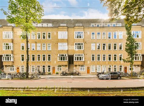 An Apartment Building With Bicycles Parked On The Street In Front Of It