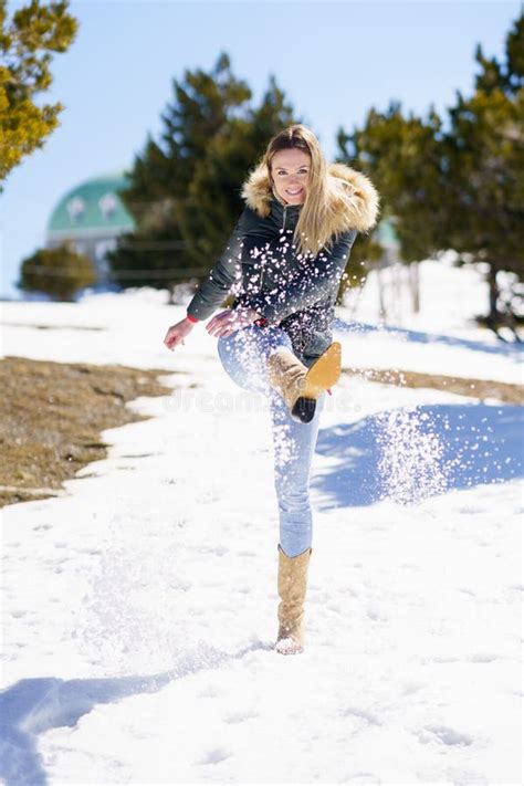 Blonde Happy Woman Kicking Snow In A Snow Covered Forest In The Mountains Stock Photo Image Of
