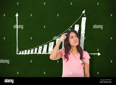 Pretty Brunette Thinking Against Green Wall With Graph Stock Photo Alamy