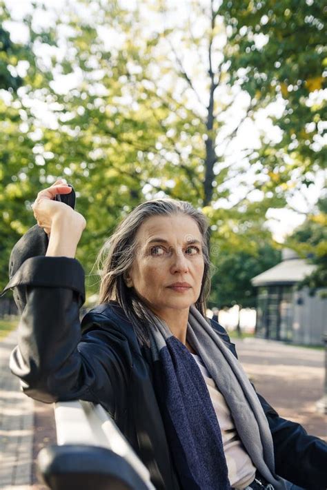 Beautiful Mature Woman In Autumn Park Flooded With Sunlight Stock Image