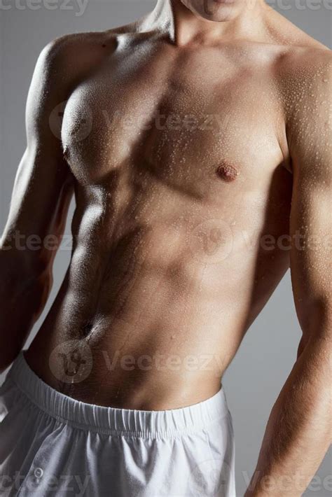 Portrait Of A Athletic Man With A Pumped Up Torso On A Gray Background And Biceps Nude Figure