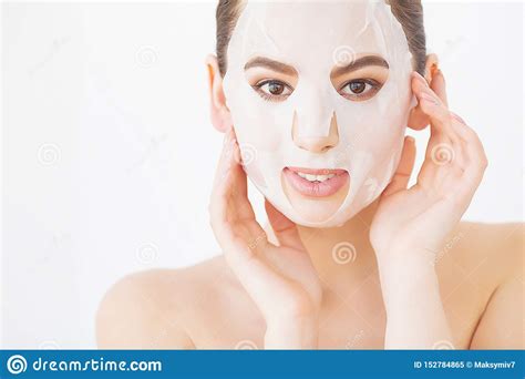 Beautiful Young Woman Is Getting Facial Clay Mask At Spa Lying With