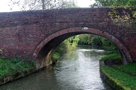 An Arched Brick Bridge Over A Small River