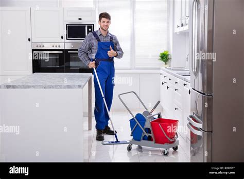 Male Janitor Cleaning Floor With Mop In Kitchen Stock Photo Alamy