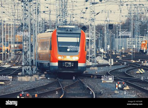 Modern Orange Commuter Train On A Railroad Railway Station In Europe