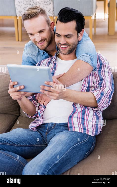 Gay Couple Relaxing On The Couch Using Tablet Stock Photo Alamy