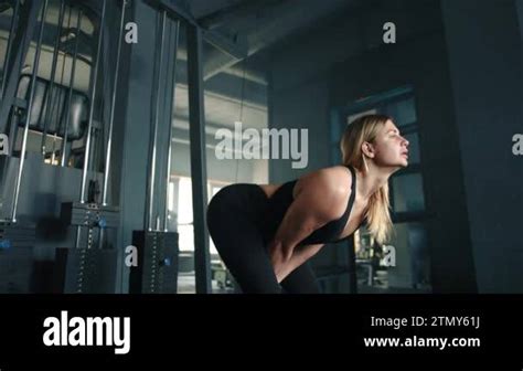 Cute Fit Blonde Performs Cable Pull Through Exercise On Cable Machine In Gym Woman Works Glutes