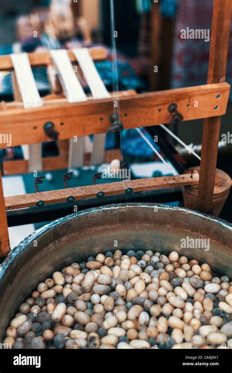 Silkworm Cocoons In Hot Water In Cauldron Traditional Spinning Wheel