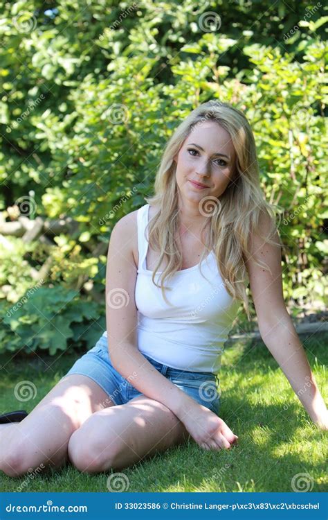 Pretty Blond Woman Relaxing In Her Garden Royalty Free Stock Image