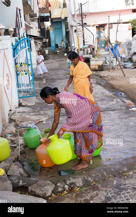 Indian Women Filling Plastic Pots With Water From A Standpipe In A