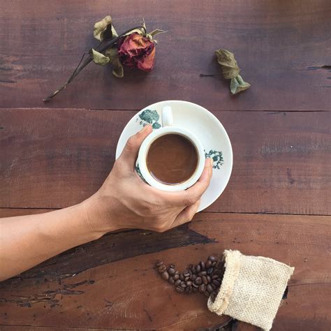 Photographie à Plat De Personne Tenant Une Tasse En Céramique Blanche