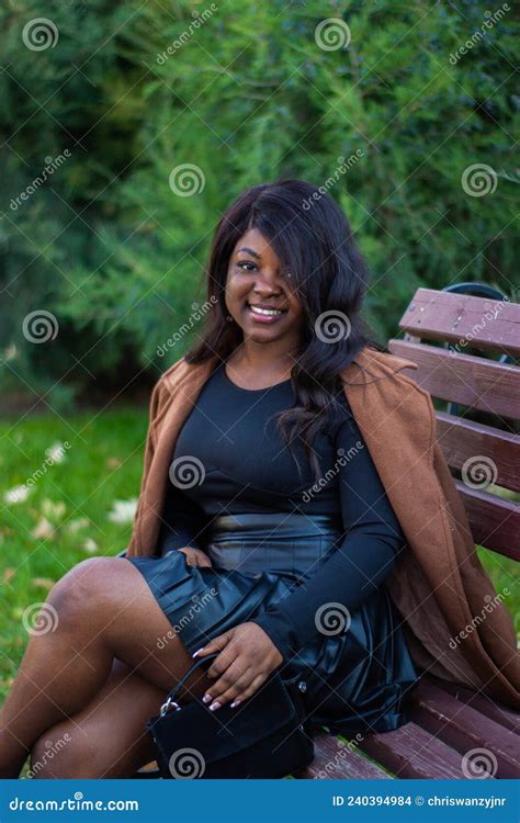 Une Belle Femme Africaine En Tenue Noire Assise Sur Un Banc De Jardin