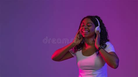 Portrait Of Happy Delighted Black Woman Listening Music In Wireless