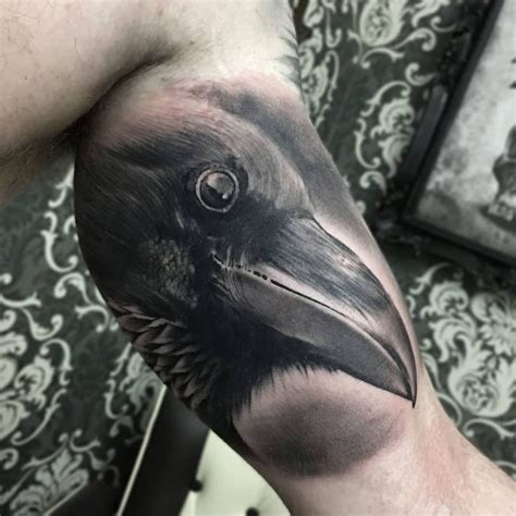 A Man S Arm With A Black And Grey Crow Tattoo On The Left Forearm