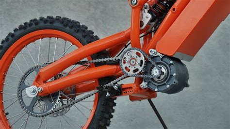 An Orange Dirt Bike Parked On Top Of A Cement Ground