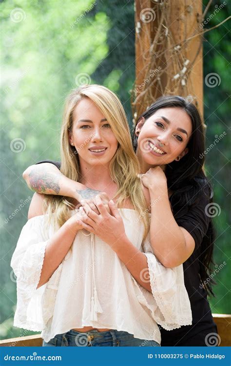 A Pair Of Proud Lesbian In Outdoors Looking At Each Other In A Garden