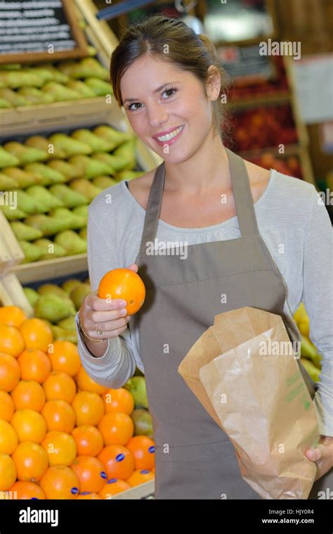 Shop Assistant Holding An Orange Stock Photo Alamy
