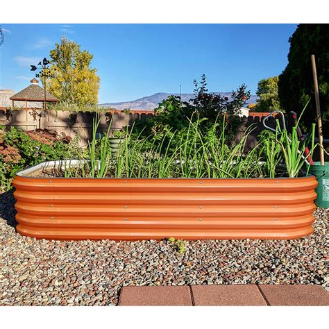 Orange Planter Box Growing Scallions In Backyard