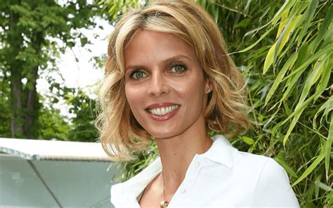 Sylvie Tellier à couper le souffle en bikini noir brillant croisé avec anneaux métalliques