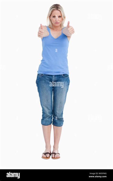 Serious Blonde Woman Showing Her Thumbs Up Against A White Background