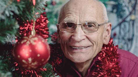 Large Scale Portrait Of Older Man Face Looking With Smile Near Christmas Tree Stock Image