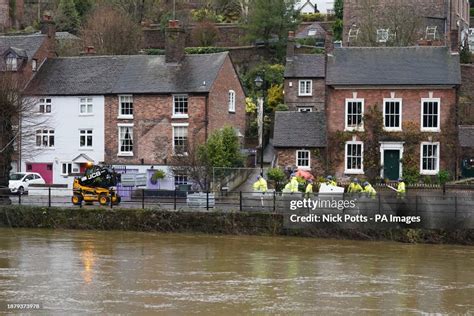 The swollen River Severn as flood defenses are put in place along the ...