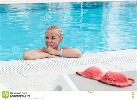 Een Blonde Jonge Vrouw In Een Zwembad Met Rode Bikini Verlaten Door De Pool Stock Afbeelding