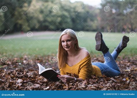 Joven Rubia Tendida En El Suelo Leyendo Un Libro Foto De Archivo