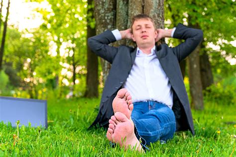 Businessman Relaxing In The Grass With His Shoes Off Stock Photos