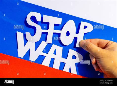 Man Holding A Hand Drawn Cutout Of An Anti War Slogan With The Russian