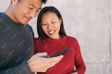 Free Photo Asian Couple Looking At The Mobile Phone