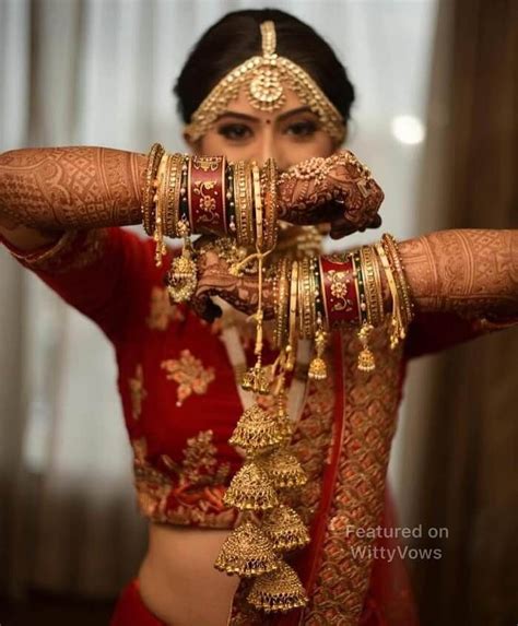 A Woman In A Red Outfit Holding Her Hands Up To Her Face With Gold