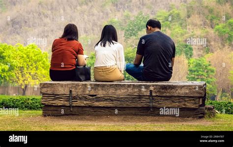 Vista trasera de la familia asiática relajante cerca de la montaña