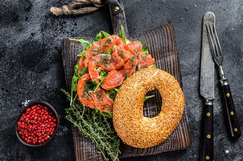 Bagel de salmón ahumado con queso tierno rúcula sobre una tabla de