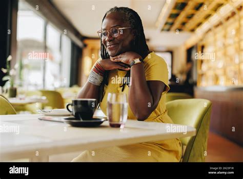 Happy Mature Woman Looking Away With A Smile While Sitting In A Cafe