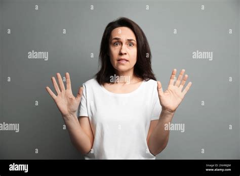 Mature Woman Feeling Fear On Grey Background Stock Photo Alamy