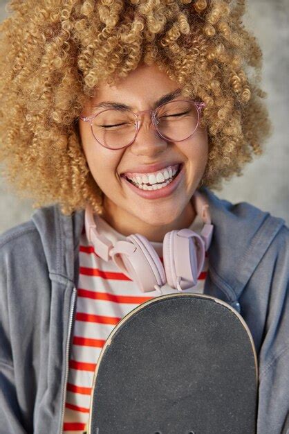 Premium Photo Positive Curly Haired Woman Smiles Broadly Wears