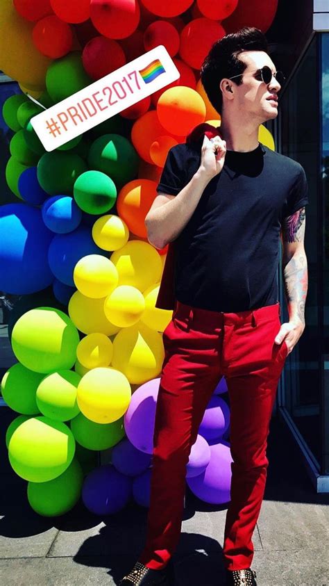 A Man In Black Shirt And Red Pants Standing Next To Colorful Balloon