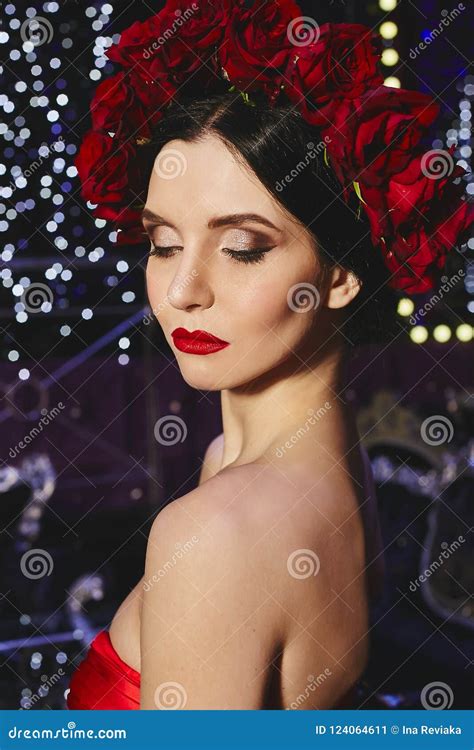 Fashionable And Brunette Slim Model Girl With Bright Makeup And With Wreath Of Red Flowers On