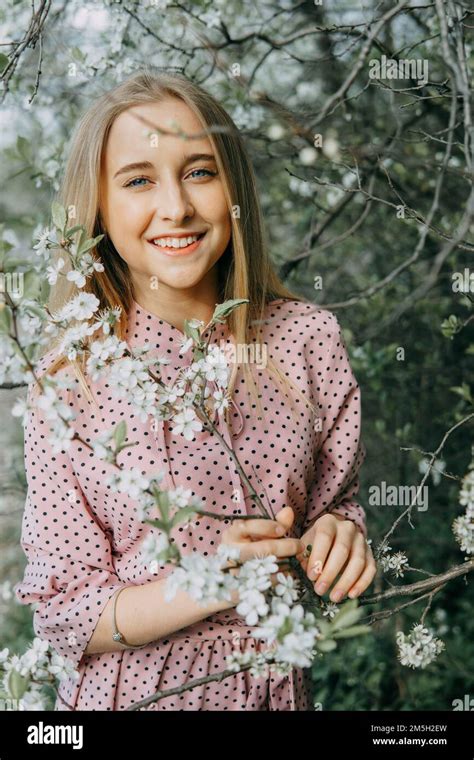 Fille blonde lors d une promenade printanière dans le jardin avec des cerisiers en fleurs